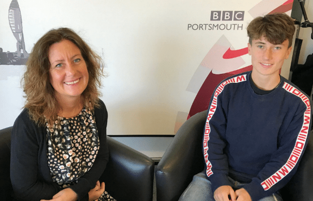 George and Amelia Ashby sat together smiling on two chairs in front of a BBC Portsmouth background.